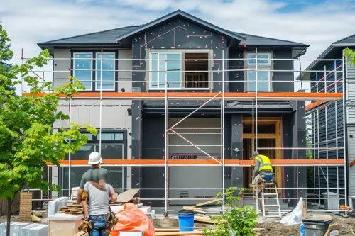 Propriétaire comparant les options d'isolation thermique pour sa maison lors d'une rénovation